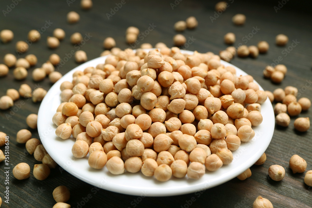 White Plate Full of Dried Chickpeas with Some Kernels Scattered Around White Plate Full of Dried Chickpeas with Some Kernels Scattered Around