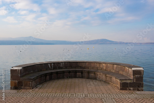 Panchina in muratura sul lago photo