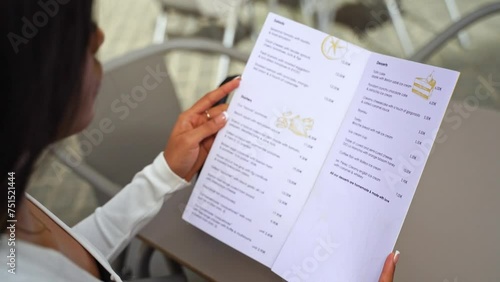 Close-up hands of Elegant Woman Hold Menu Restaurant Choosing Dish or Beverage Lunch City Break. Eating in Public Places Cafeteria. Ordering for waiter. Slim Woman Diet Catering Alcohol Drink Dish.