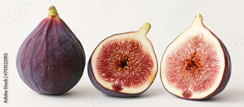 Fresh ripe figs with a cut in half and a whole fig in the middle on a wooden table