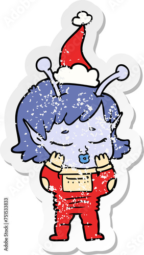 distressed sticker cartoon of a alien girl wearing santa hat