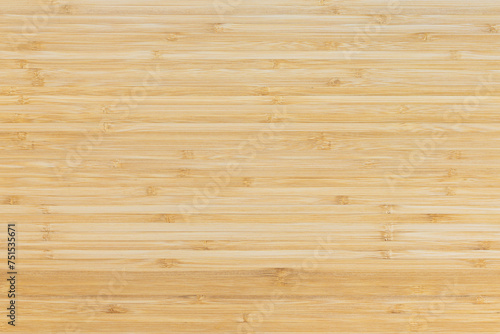 Bamboo wood texture background. Woodgrain of a board as empty copy space. Natural tropical material close up of a furniture part.