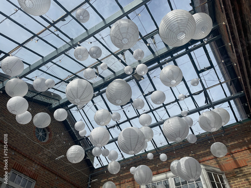 Round white lamp shades have been hung from a glass roof for artistic effect.Decoration