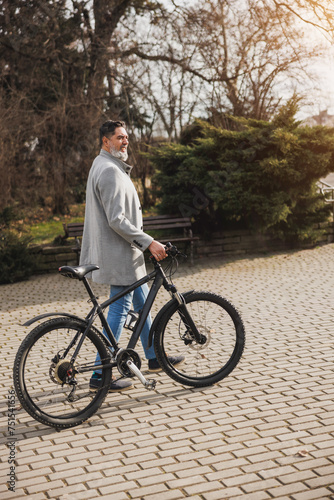 Man Walking With Bike In City Park