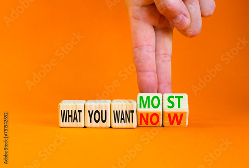 What you want now or most symbol. Concept word What you want now or most on cubes. Beautiful orange background. Psychologist hand. Psychological what you want now or most concept. Copy space.