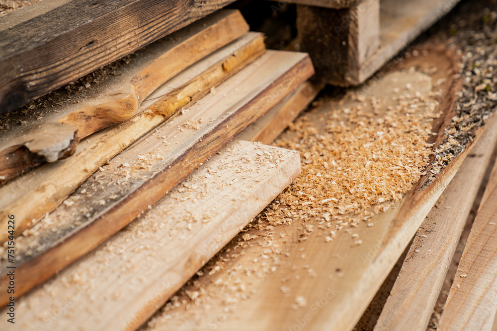 Cut wooden lumber boards at carpenters with a lot of sawdust on the different types of wood. Timber wood planks on top of each other outside the carpentry Cut wooden lumber boards at carpenters with a lot of sawdust on the different types of wood. Timber wood planks on top of each other outside the carpentry
