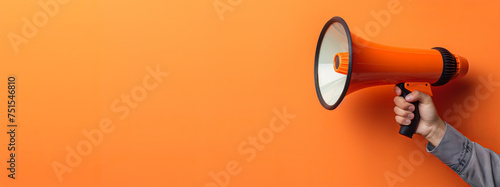 Hand holding a megaphone announces sales and discounts, on a vibrant orange background. Marketing and commercial concept banner with copy space, made with Generative AI. photo