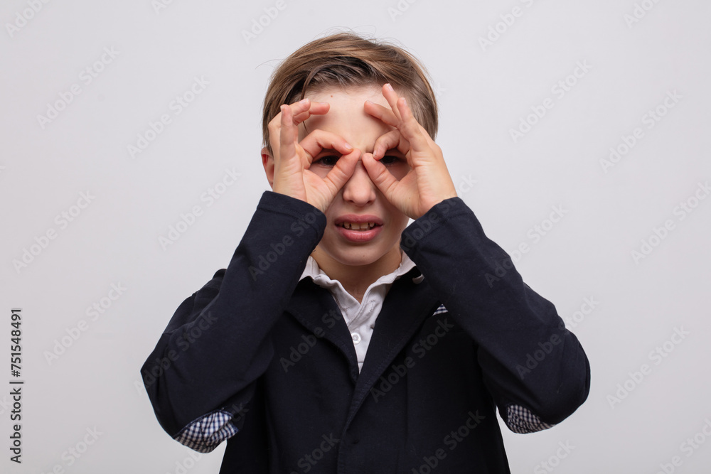 A teenage boy showed glasses or binoculars with his fingers. A teenage boy showed glasses or binoculars with his fingers.
