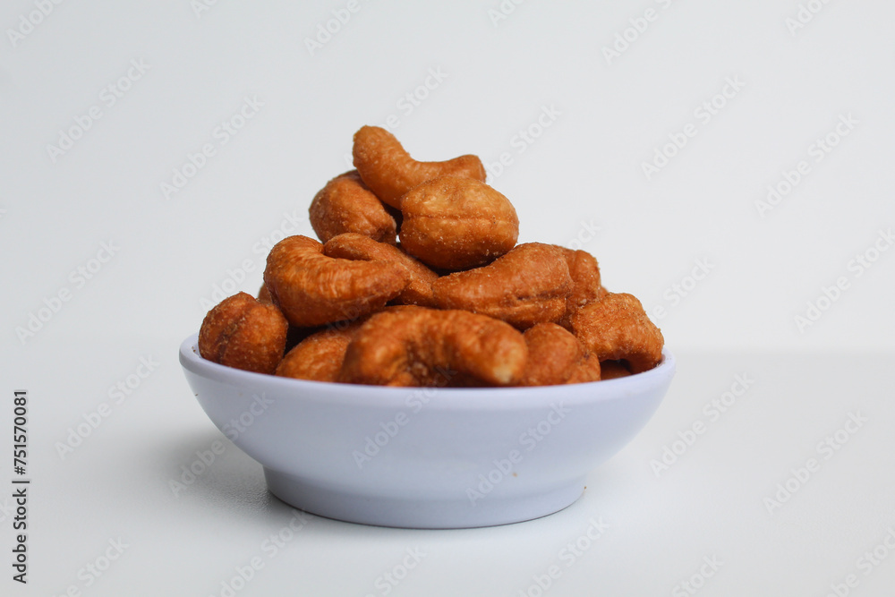 Cashew nut in a white small bowl. isolated on white background, side view Cashew nut in a white small bowl. isolated on white background, side view