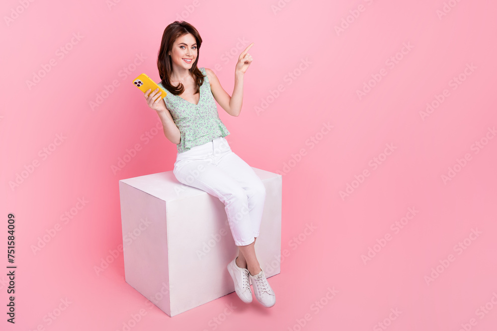 Photo of gorgeous cute girl popular blogger showing empty space seasonal offer news isolated on pink color background Photo of gorgeous cute girl popular blogger showing empty space seasonal offer news isolated on pink color background