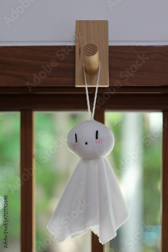 Teru teru bozu, small traditional handmade white cloth dolls, hang on window frames. photo