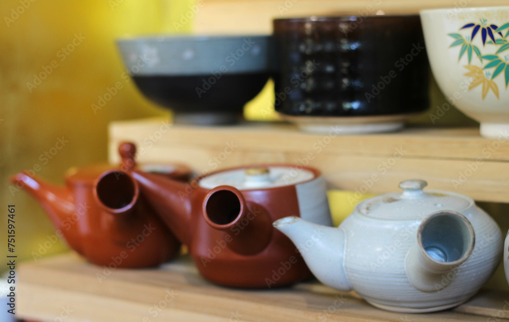 Ceramic sets displayed on wooden shelves.
