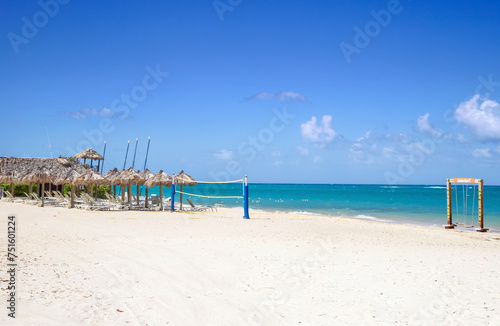 Tropical beach with active recreation on the Caribbean Islands, volleyball, chairs and umbrella a sunny day