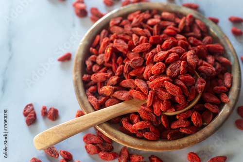 Bild auf Leinwand Dried  goji berries in ceramic plate with wooden spoon.