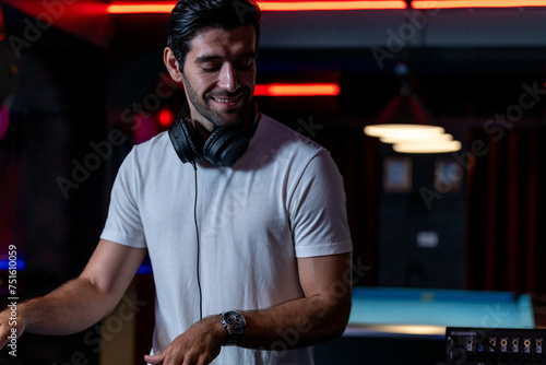 DJ musician man playing and mixing a song with a turntable and headphone. Dance party. excited dj sound device operator with headphones by dancing at club. concept of entertainment in nightlife.
