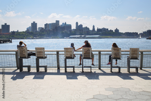 Fotografi People sit on chairs and admire the views of the Brooklyn side of Manhattan