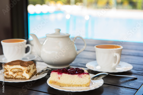 Afternoon tea set with hot tea and tasty cakes