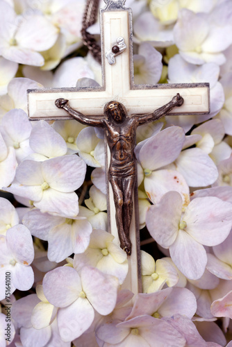 Prayer beads on flowers. Crucifix with Jesu. Catholic sympbol. photo