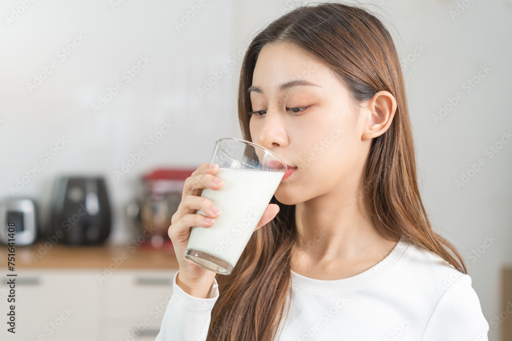 Health care, pretty asian young woman, girl drinking a glass of white fresh, dairy milk for calcium, vitamin wholesome good nutrition in morning at kitchen home. lifestyle, product healthy people. Health care, pretty asian young woman, girl drinking a glass of white fresh, dairy milk for calcium, vitamin wholesome good nutrition in morning at kitchen home. lifestyle, product healthy people.