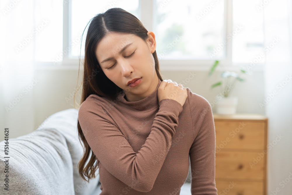 Pain body muscles stiff problem, suffer asian young woman, girl painful with back, holding neck ache from work hand holding massaging rubbing shoulder hurt, sore sitting on couch at home. Health care Pain body muscles stiff problem, suffer asian young woman, girl painful with back, holding neck ache from work hand holding massaging rubbing shoulder hurt, sore sitting on couch at home. Health care