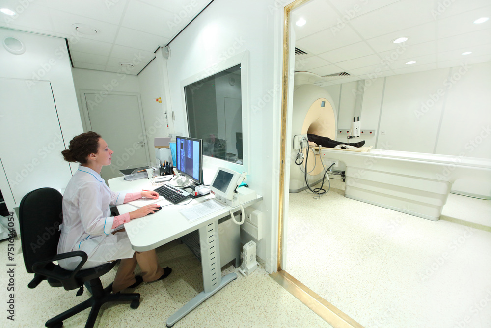 Doctor in control room, and magnetic resonance imaging machine with patient Doctor in control room, and magnetic resonance imaging machine with patient