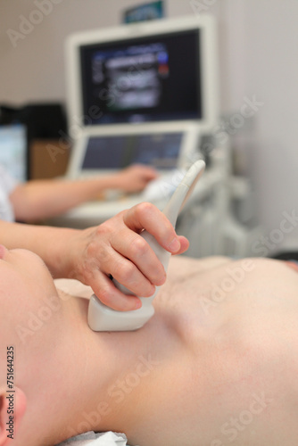 Doctor examining patient with thyroid ultrasound  throat in focus