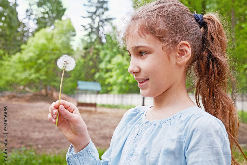 Humeral outdoor portrait of smiling girl with blowball in her hand Humeral outdoor portrait of smiling girl with blowball in her hand