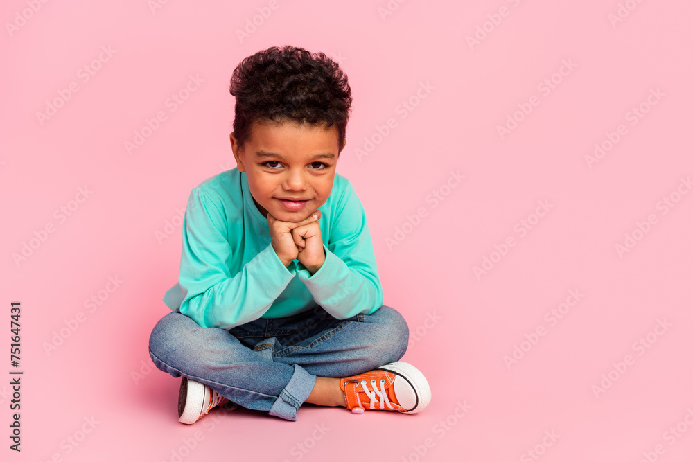 Full size photo of charming small boy sit floor look minded camera wear trendy aquamarine outfit isolated on pink color background Full size photo of charming small boy sit floor look minded camera wear trendy aquamarine outfit isolated on pink color background