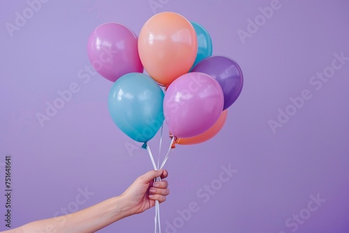 a hand holding a bunch of balloons