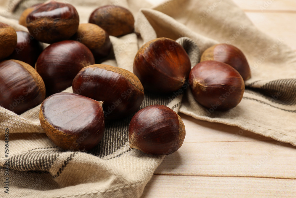 Sweet fresh edible chestnuts on light wooden table, closeup Sweet fresh edible chestnuts on light wooden table, closeup