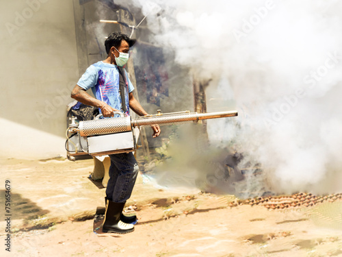 Thai man work fogging to eliminate mosquito for preventing spread dengue fever and zika virus , Buriram Thailand.