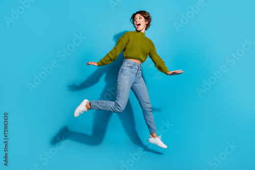 Full length photo of adorable cheerful girl wear stylish clothes running away looking empty space isolated on cyan color background