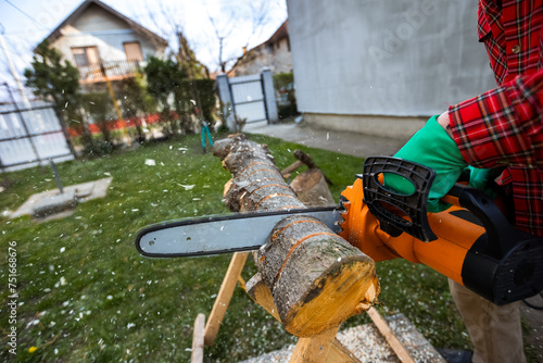 Man cutting wood with saw, dust and movements. Chainsaw.
