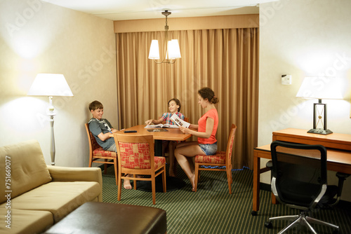 Mom with two kids read magazines at the table photo