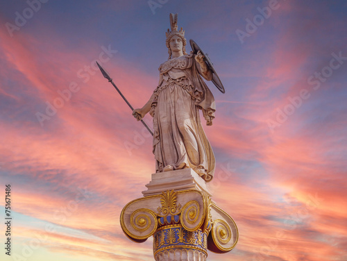Athena statue, the ancient Greek goddess of wisdom, stands on an Ionic style column under a fiery sky. Romantic moment in Athens, Greece.