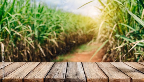 the empty wooden brown table top with blur background of sugarcane plantation exuberant image