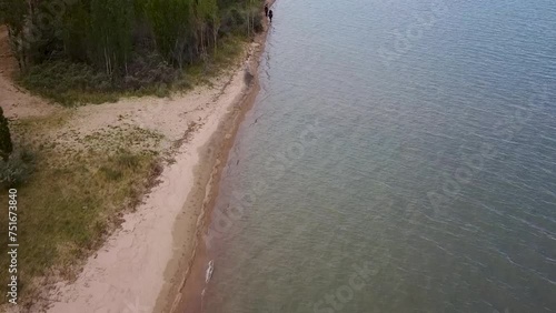 Riders on horseback stroll along the shore of Lake Issyk-Kul
