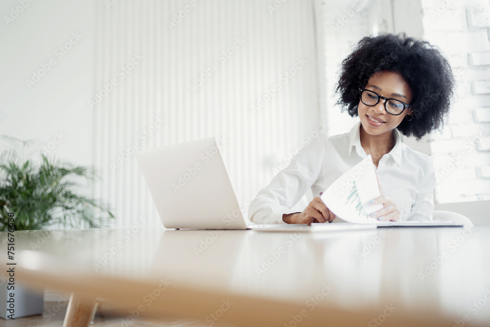 Focused entrepreneur analyzing charts with a laptop at a minimalist workspace, highlighting dedication and analytical skills. Focused entrepreneur analyzing charts with a laptop at a minimalist workspace, highlighting dedication and analytical skills.