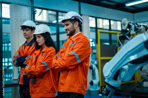 Portrait of Robotics engineers working with Programming and Manipulating Robot Hand, Industrial Robotics Design, High Tech Facility, Modern Machine Learning. Mass Production Automatics.