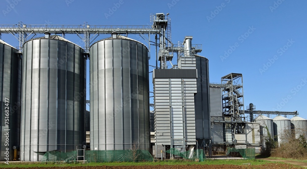 Grain storage bins with silos and elevator tower in the countryside.