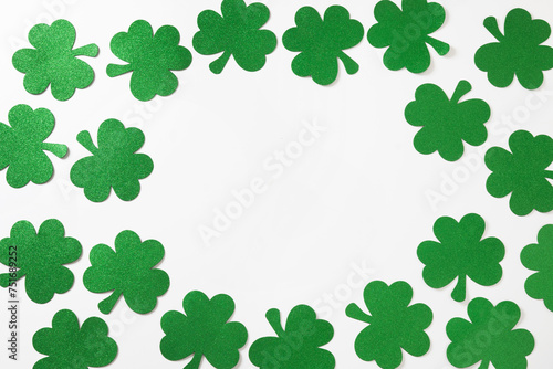 St. Patrick's day frame with clover leaves, horseshoe on white background. Flat lay. View from above. Greeting card with copy space.