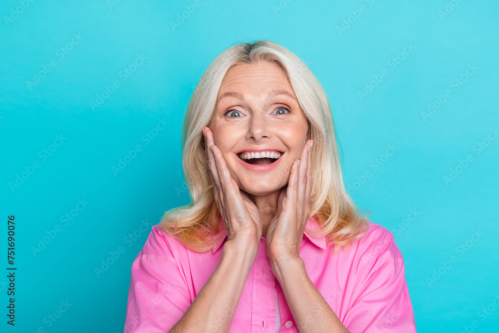 Photo of attractive retired woman touch cheeks shocked dressed stylish pink smart casual clothes isolated on aquamarine color background