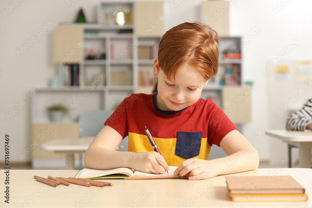 Cute little boy studying in classroom at school Cute little boy studying in classroom at school