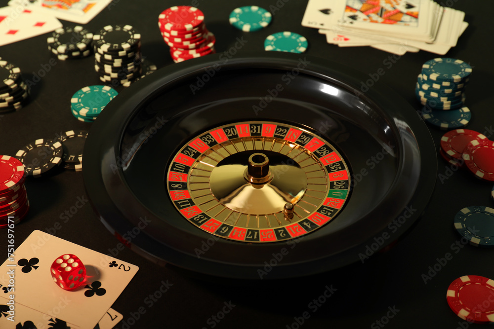 Roulette wheel, playing cards and chips on table, closeup. Casino game Roulette wheel, playing cards and chips on table, closeup. Casino game