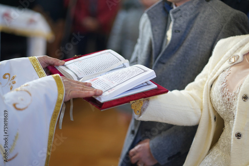 The newlyweds hold the Gospel, which is read by the priest during the wedding ceremony. The photo was taken in soft focus.