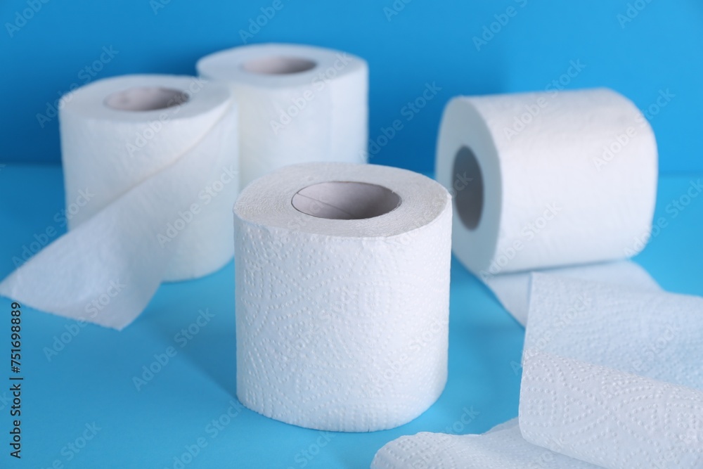Soft toilet paper rolls on light blue background, closeup Soft toilet paper rolls on light blue background, closeup