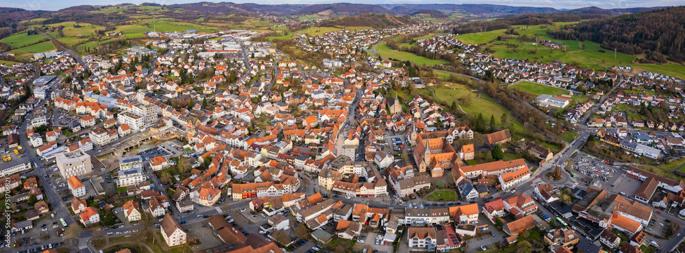 Aerial around the old town of the city Schlüchtern in Hessen, Germany on a cloudy day in early spring