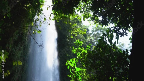 Shot of Misol Ha waterfall framed by jungle leaves in Chiapas, Mexico photo