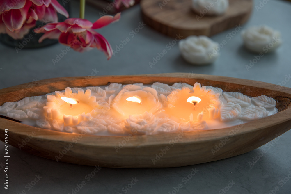 Candle in a wooden form in the shape of flowers