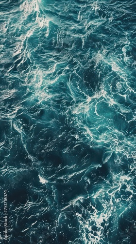Blue sea water texture background. Top view of sea surface with waves © Christiankhs